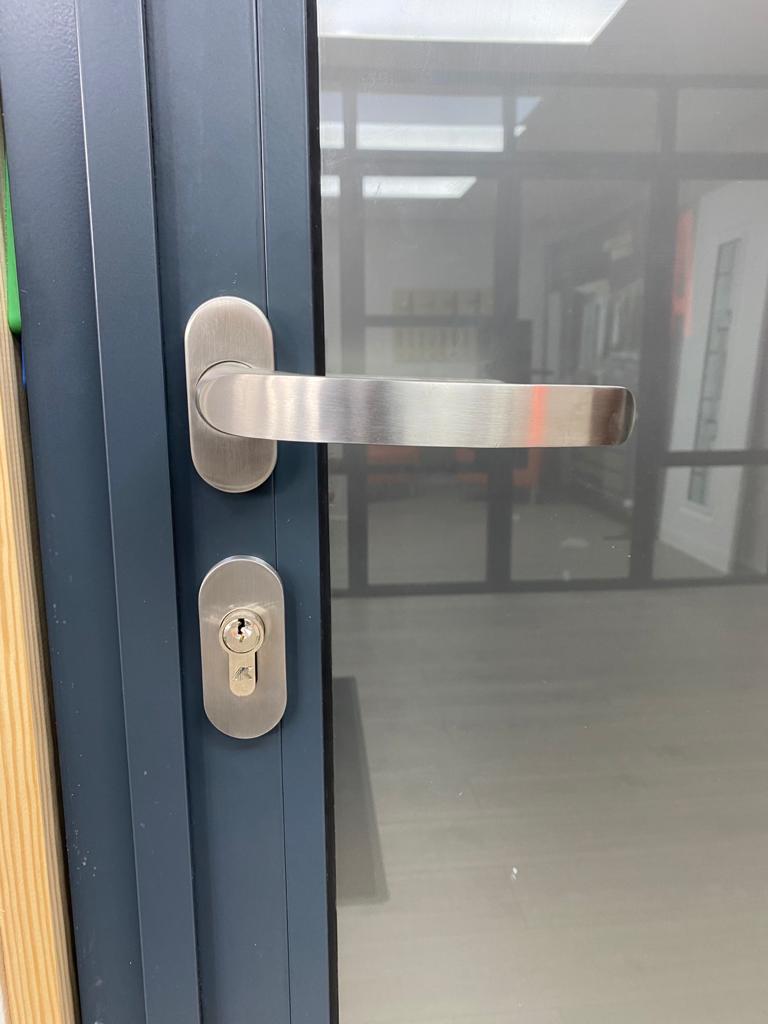 A sliver door handle on a blue door.