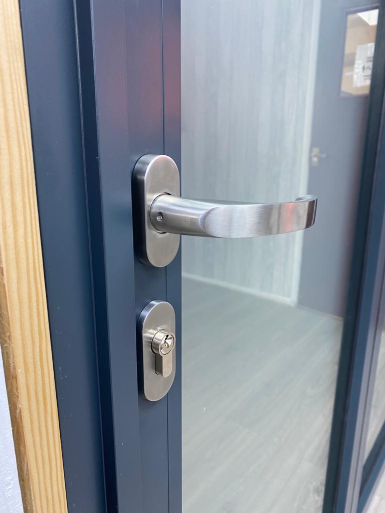 A sliver door handle on a blue door.